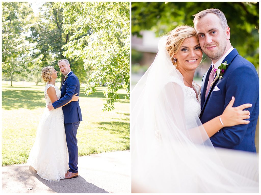 bride and groom smiling at camera with veil blowing in the wind