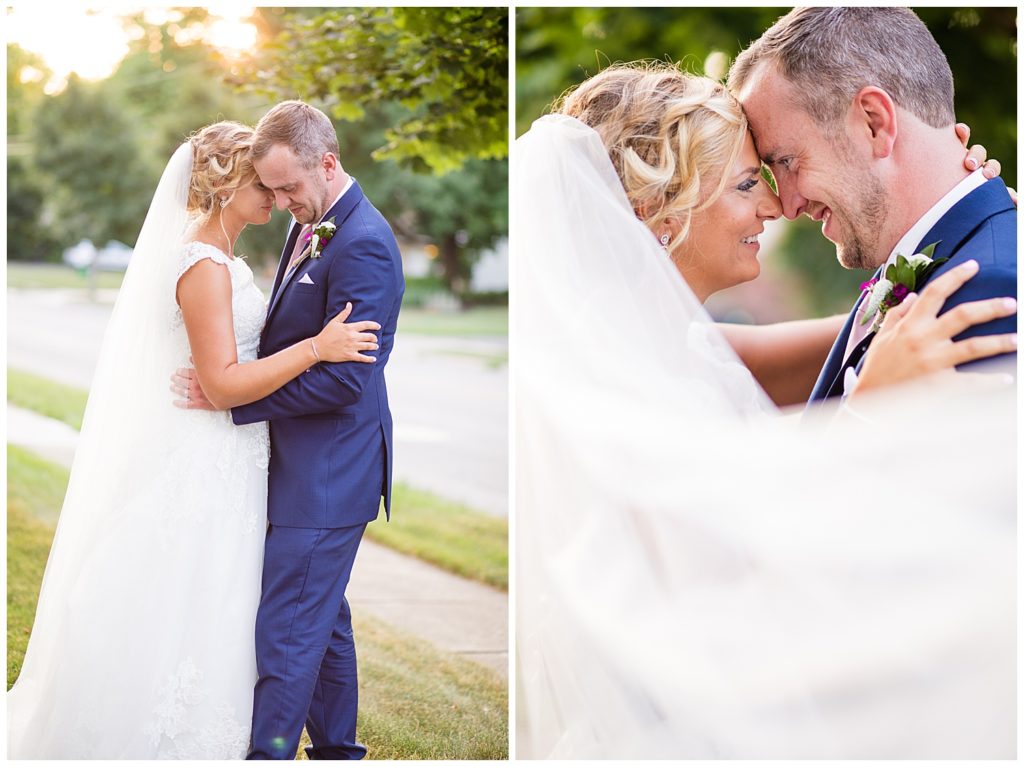 bride and groom touching foreheads while veil blows in wind