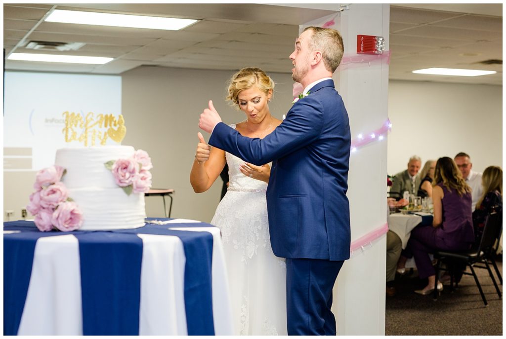 bride and groom give thumbs up after eating cake