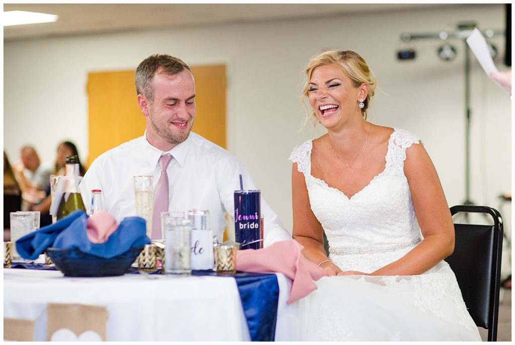 bride and groom laughing during maid of honor's speech