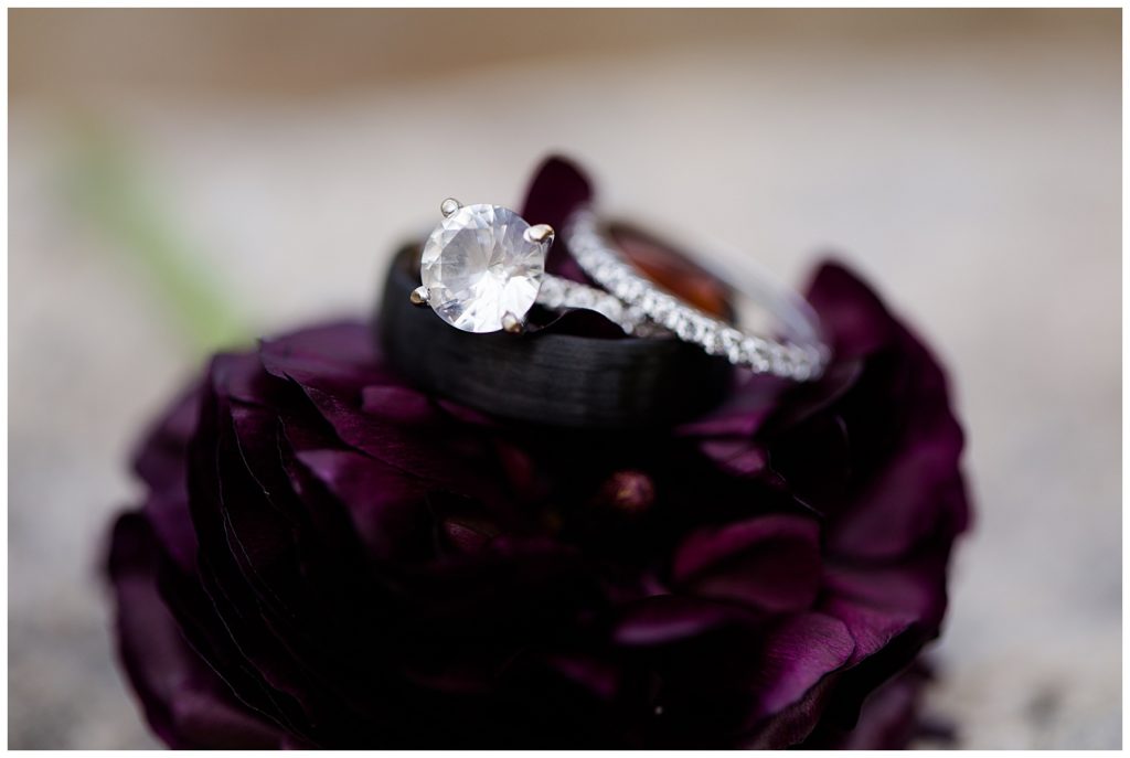 A photograph of a closeup look at the wedding rings atop a beautiful flower at the Cedar Grove Lodge wedding venue by Columbus OH wedding photographer, Alayna Parker Photography