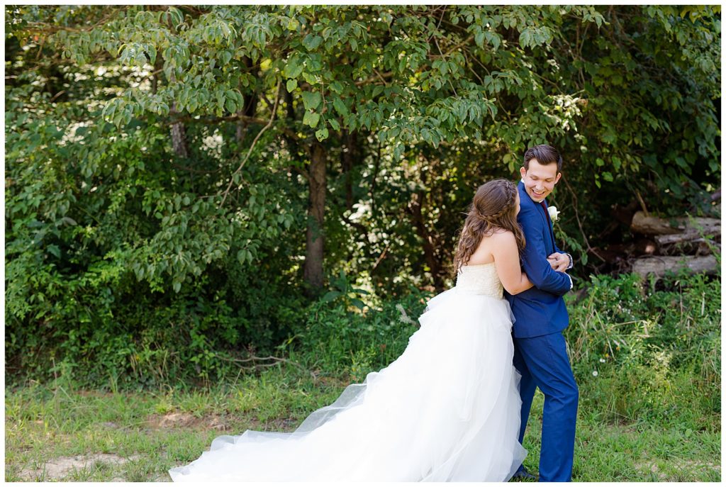 A photograph of the bride approaching her groom from behind for the first look before the wedding at the Cedar Grove Lodge venue in Hocking Hills, Ohio by Columbus OH wedding photographer, Alayna Parker Photography