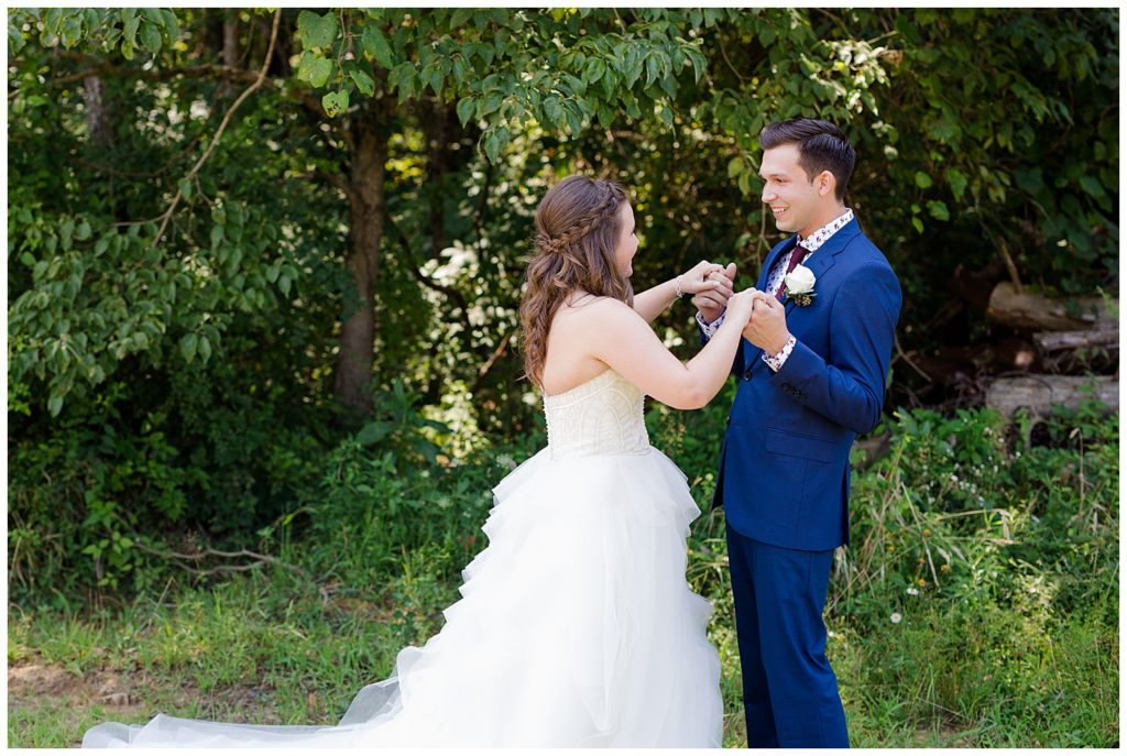 A picture of the bride and groom's first look at each other before the wedding ceremony at the Cedar Grove Lodge wedding venue by Columbus wedding photographer, Alayna Parker Photography