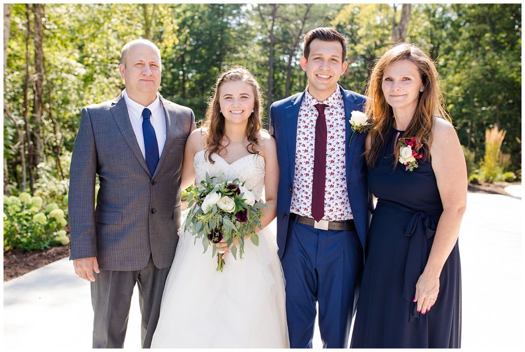 An image of the bride and groom together with their parents following the wedding at the Cedar Grove Lodge wedding venue by Columbus Ohio wedding photographer, Alayna Parker Photography