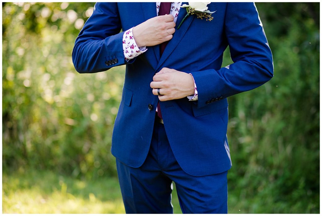 close up of groom fixing tie