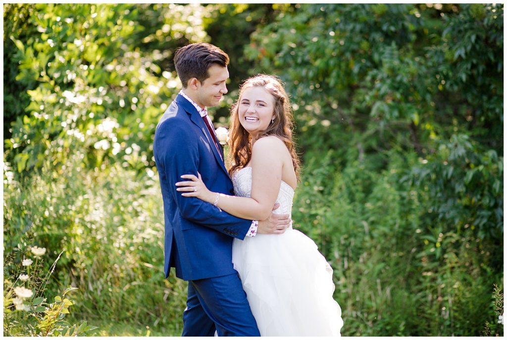 bride laughing at camera while groom looks at her