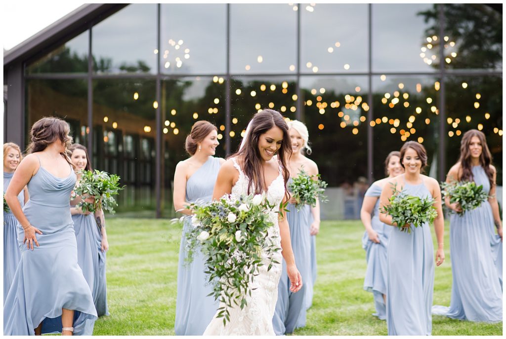 An image of the bride and bridesmaids relaxing together in front of the wedding reception venue at an Jorgensen farms Oak Grove wedding venue by Columbus Ohio wedding photographer, Alayna Parker Photography