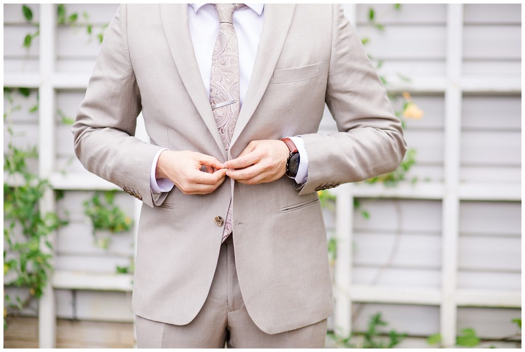 groom buttoning jacket