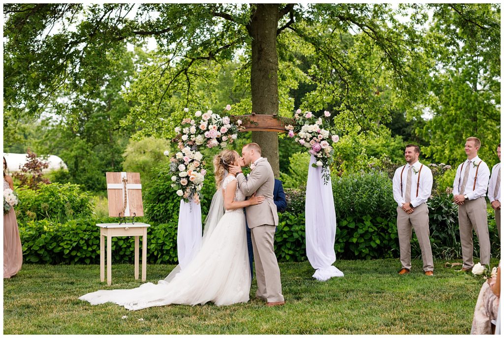 bride and groom share first kiss at jorgensen farms