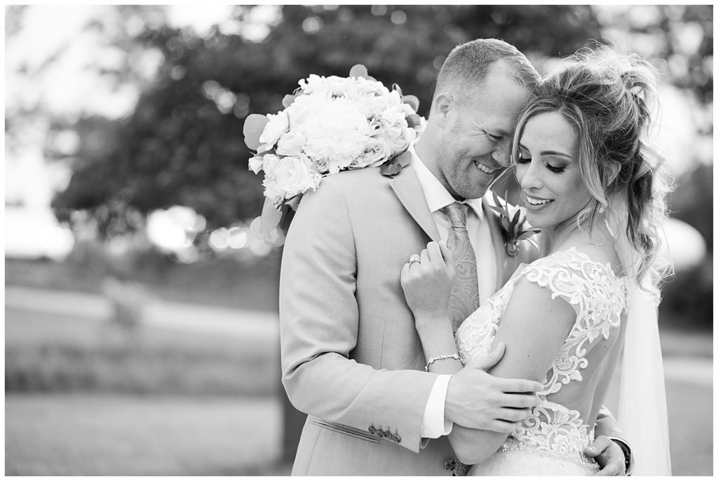 black and white image of bride and groom hugging at jorgensen farms