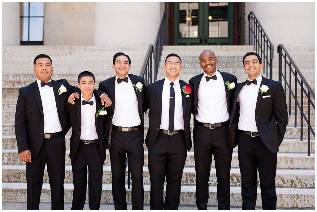 groom and groomsmen with arms around each other at ohio statehouse