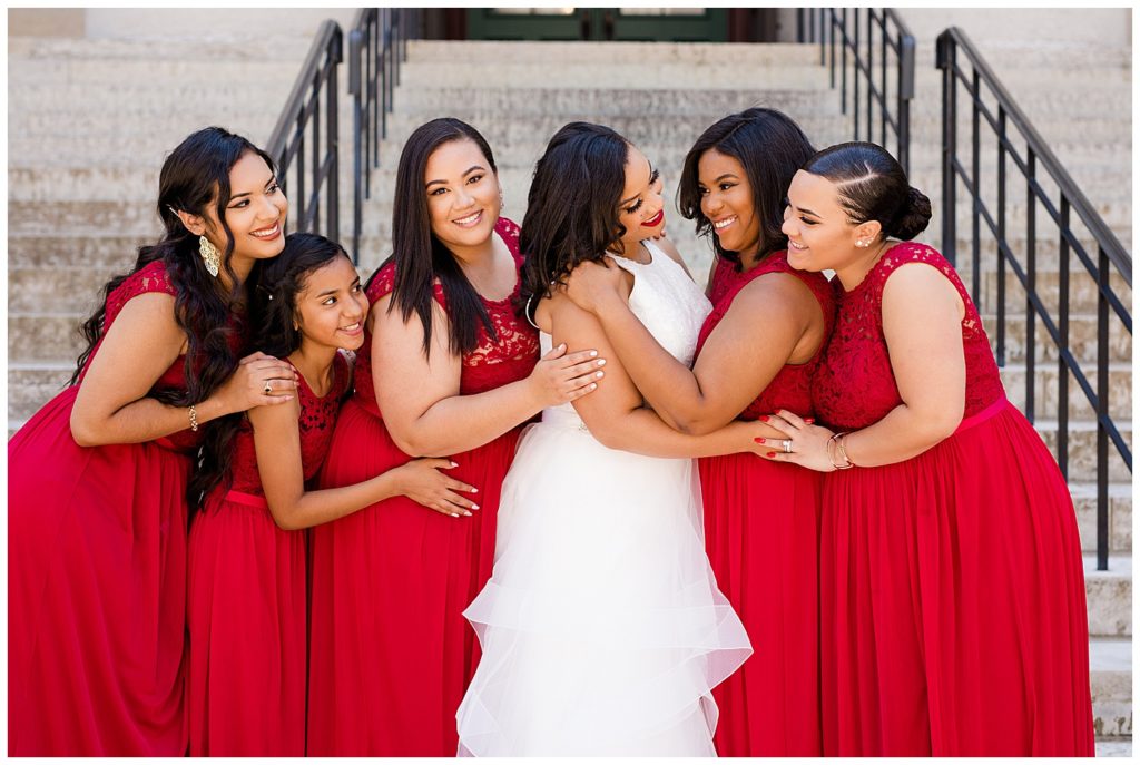 bride and bridesmaids hugging each other and smiling