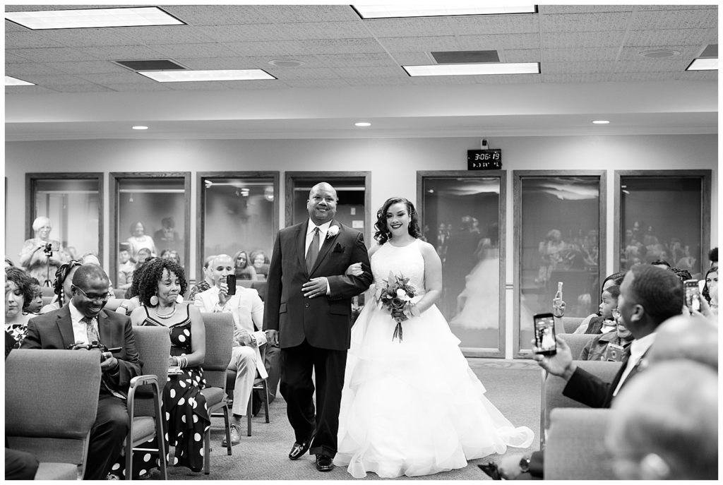 black and white image of bride walking down the aisle at kingdom hall