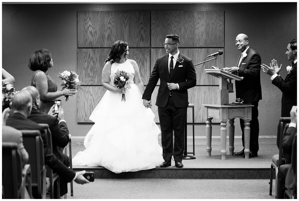 black and white image of bride and groom smiling after being pronounced husband and wife at kingdom hall