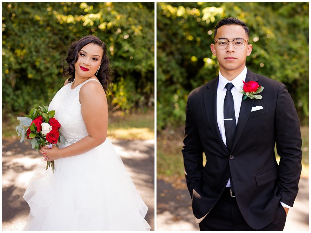 groom wearing black suit, black tie, and red rose boutonniere looking at camera