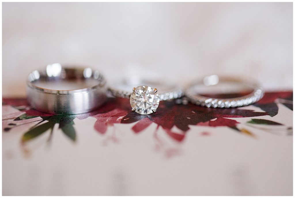 An image of a closeup of the wedding rings beautifully resting on the wedding invitation by Columbus Ohio wedding photographer, Alayna Parker Photography