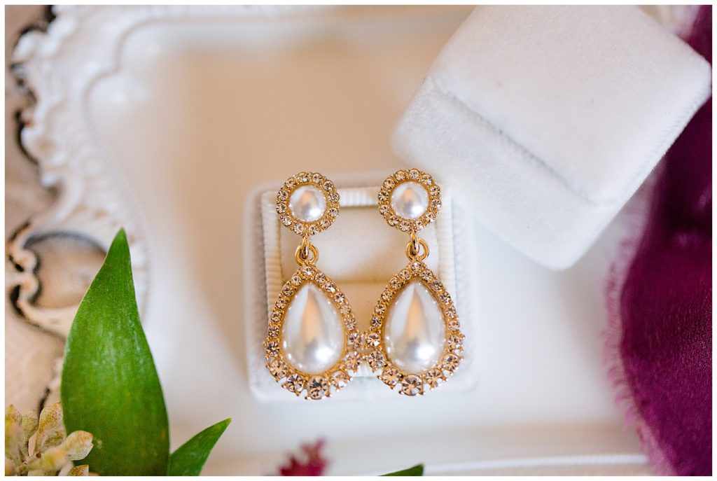 An image of a closeup of the bride's earrings before she puts them on for her wedding by Columbus Ohio wedding photographer, Alayna Parker Photography