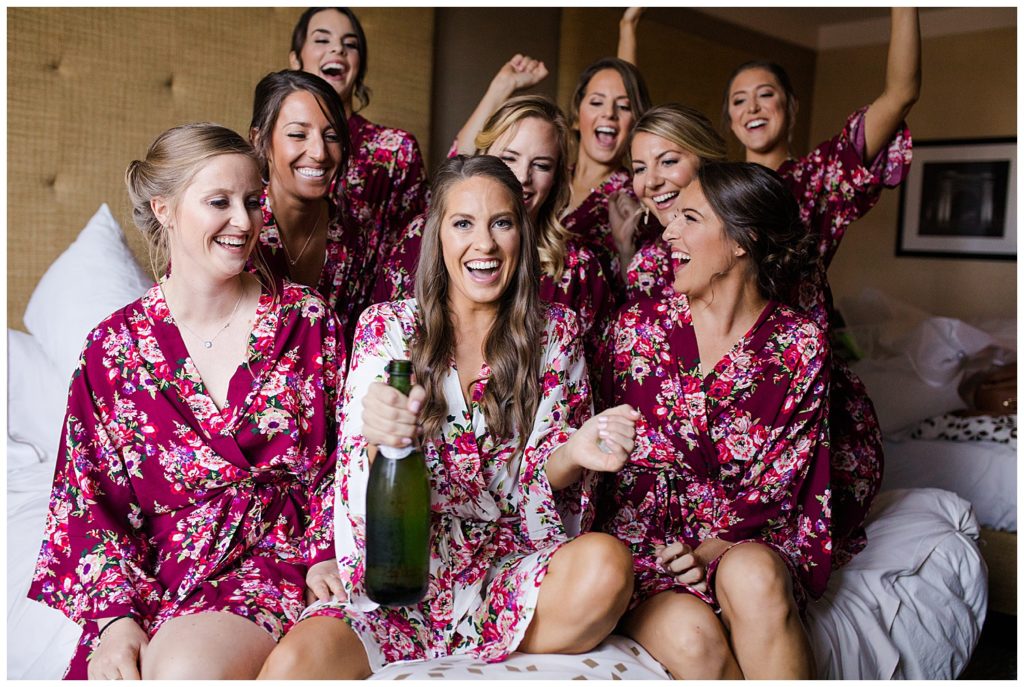 An image of a bride laughing and relaxing with her bridesmaids before they get ready for the wedding ceremony by Columbus Ohio wedding photographer, Alayna Parker Photography