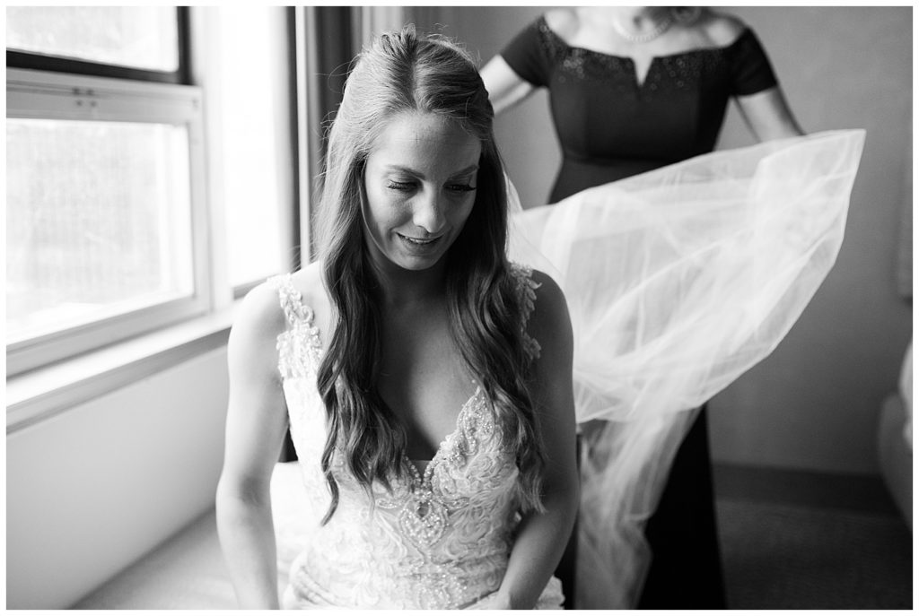 black and white image of mom fluffing brides veil at renaissance hotel