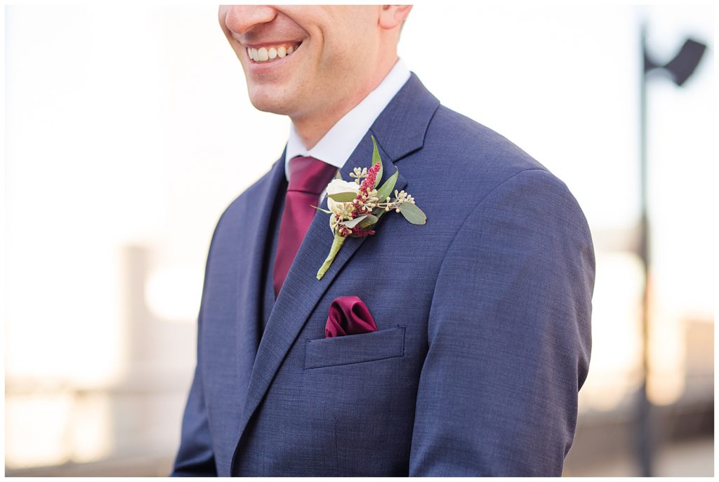 close up of groom's boutonniere with white rose and eucalyptus