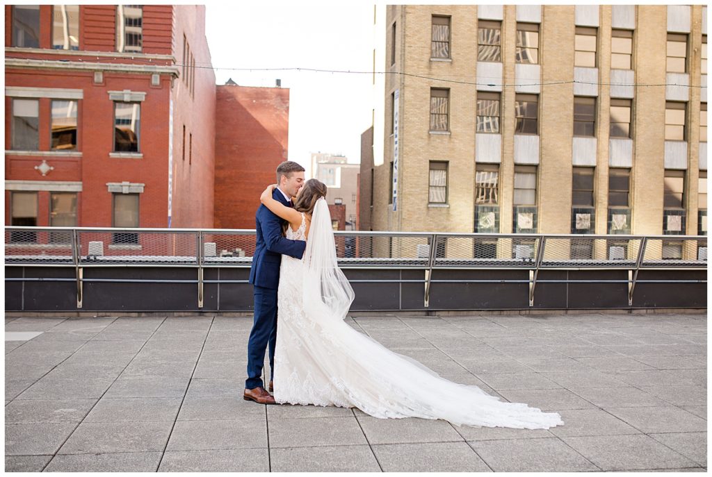 bride and groom kiss after first look on rooftop at renaissance hotel