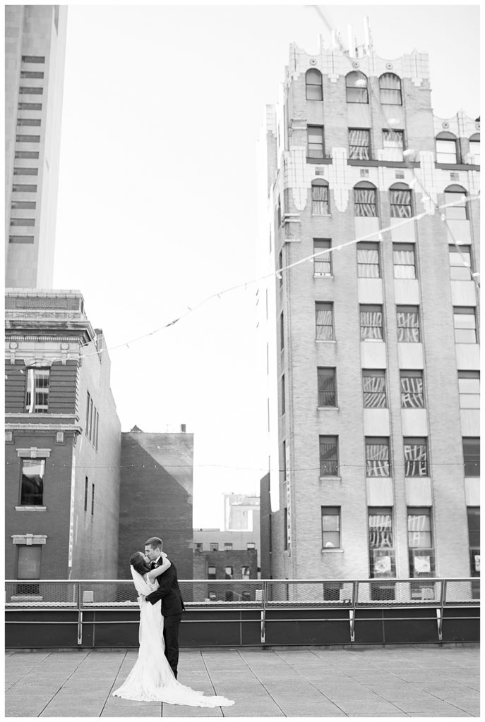 black and white image of bride and groom kissing after first look on rooftop at renaissance hotel