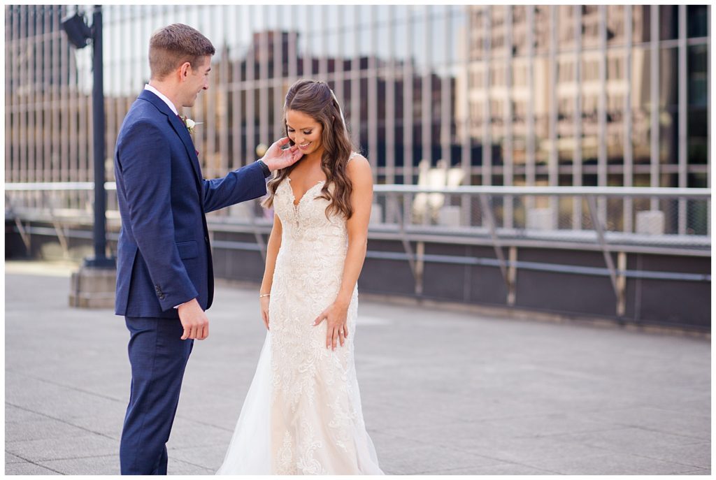 groom strokes bride's cheek on rooftop at renaissance hotel