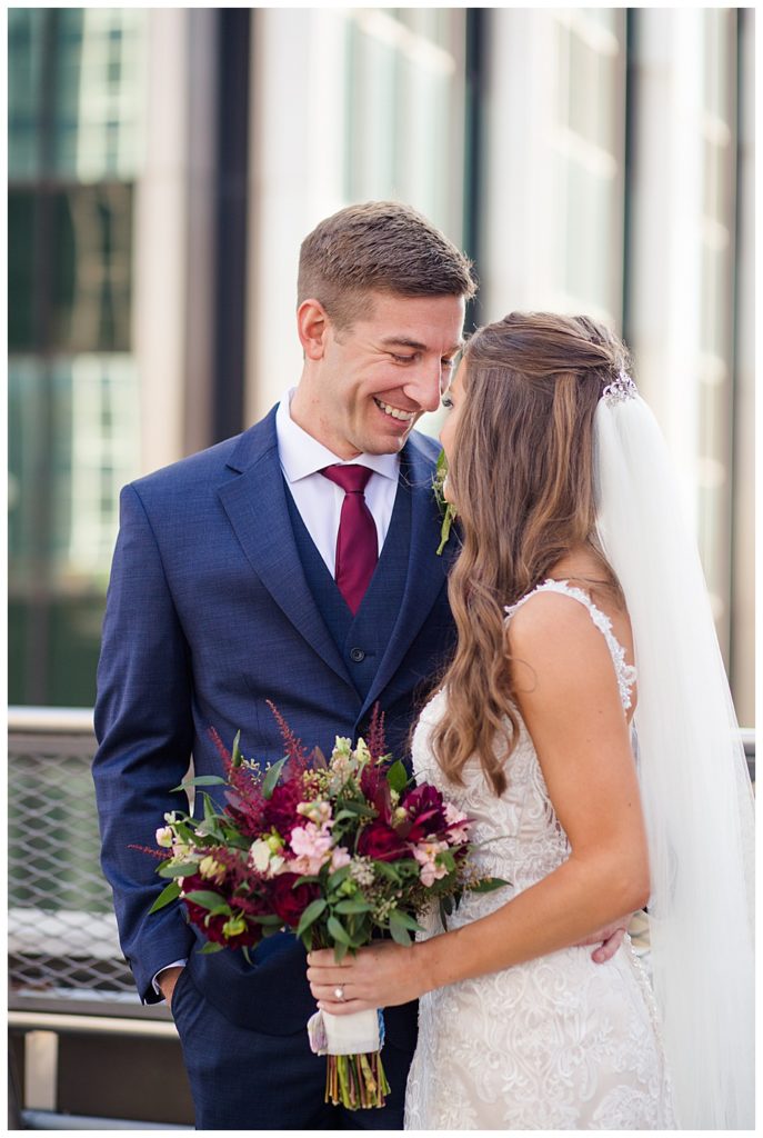Groom smiling at bride on rooftop at renaissance hotel