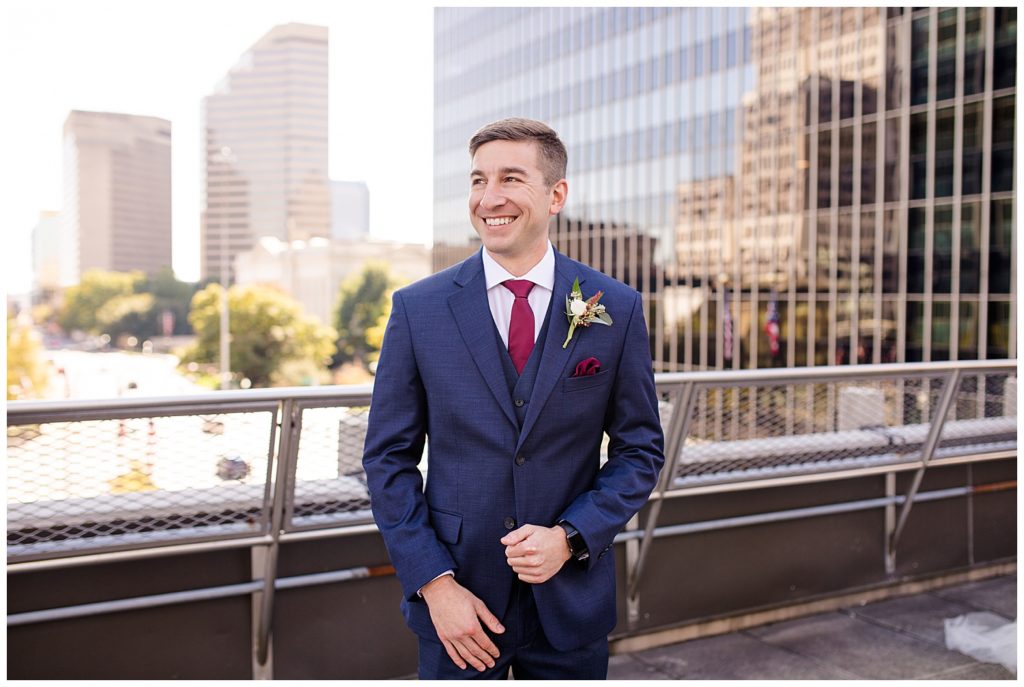 groom smiling off in the distance on rooftop at renaissance hotel