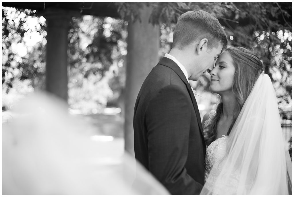 black and white image of bride and groom touching foreheads at schiller park in german village