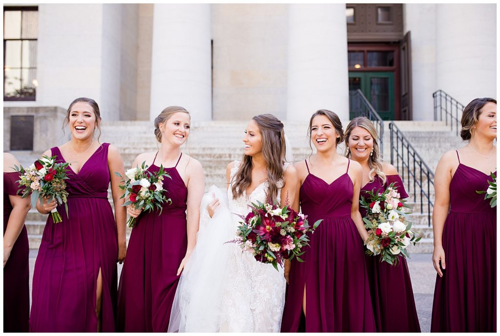 bride and bridesmaids laughing and talking while they walk outside ohio statehouse