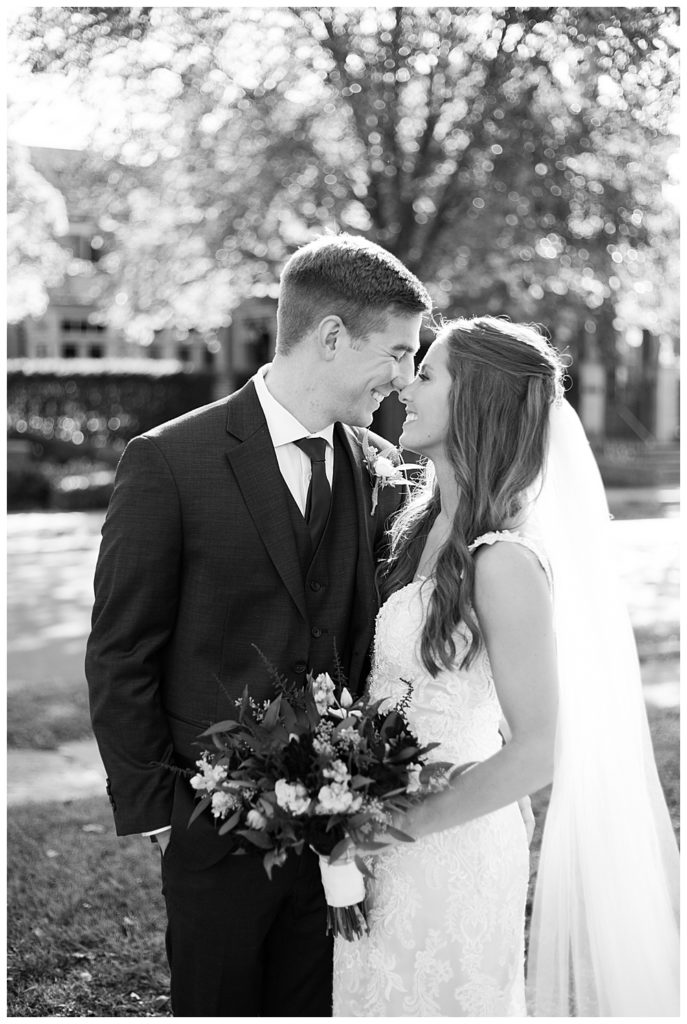 black and white image of bride and groom touching noses at schiller park in german village
