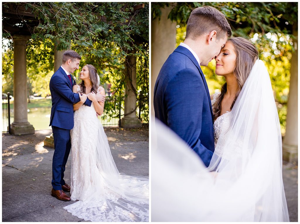 bride and groom touching foreheads while veil blows in wind at schiller park in german village