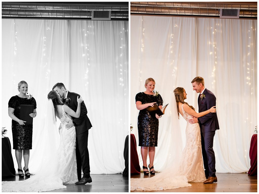 black and white image of bride and groom having first kiss at copius