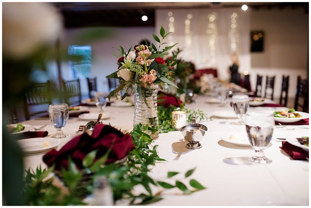 bouquets in glass vases on head table at copius
