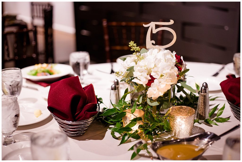 white and burgundy floral centerpiece at copius