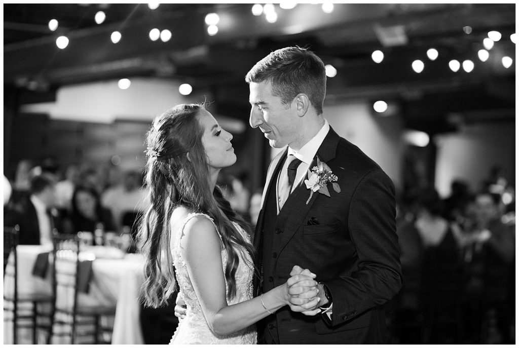 black and white image of bride and groom sharing first dance at copius