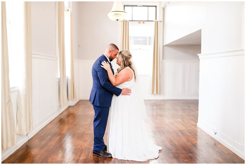 bride and groom standing with foreheads touching at the postmark