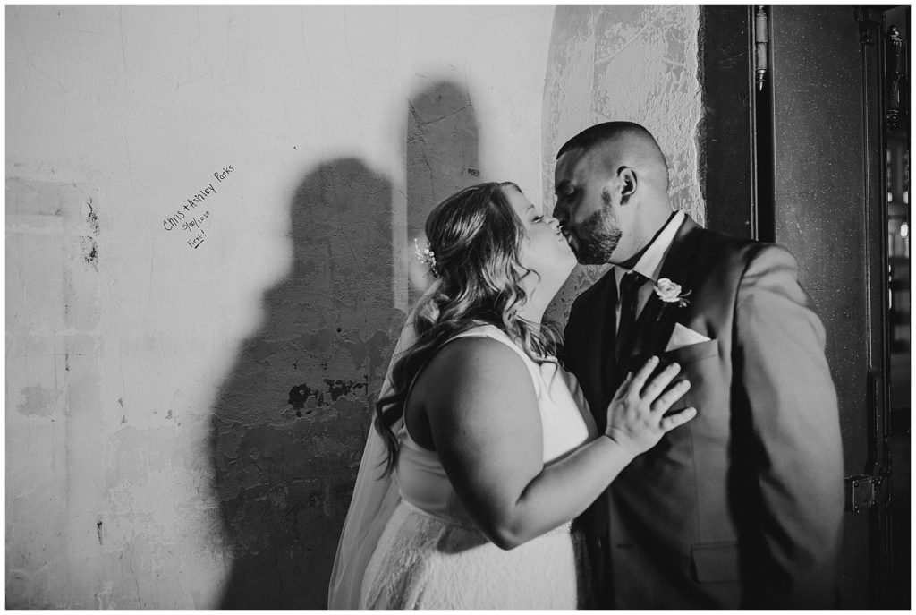 black and white image of bride and groom siging the vault at the postmark