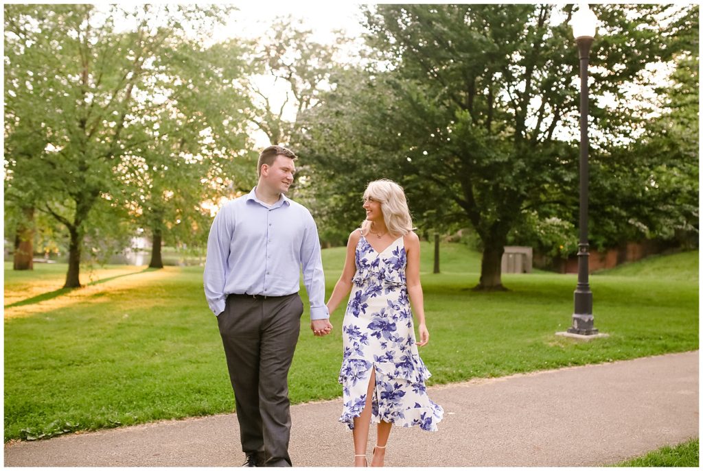 engaged couple walking on path at schiller park